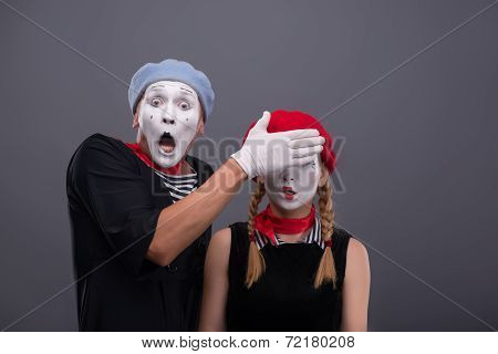 Portrait of sad mime couple crying isolated on grey background