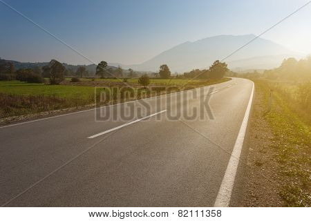Driving On An Empty Road Towards The Mountain