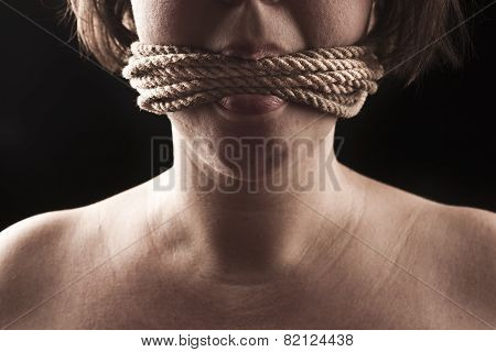 Submissive Girl Gagged With Rope On A Black Background