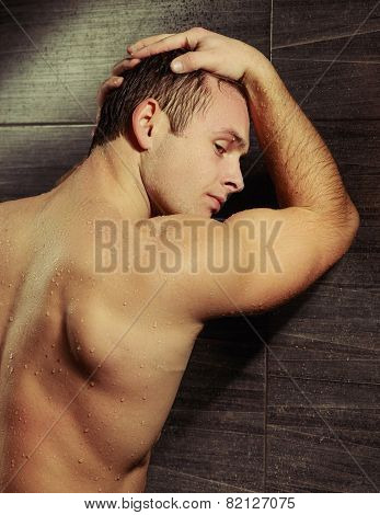 Handsome young man taking a shower