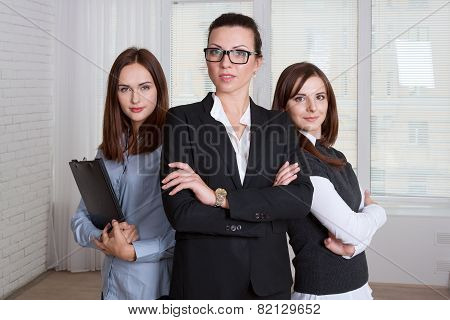 Women In Formal Clothes Are Of Different Heights With His Arms Crossed
