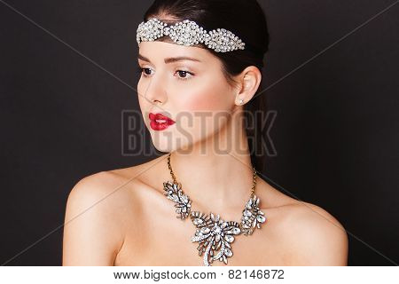 Beautiful woman with evening make-up, luxury necklase and big jewelry on her head. Beauty face.