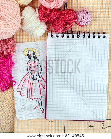 opened notebook with a draft scetch fashion dress
