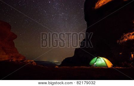 milky way above the mountains with tent highlighted