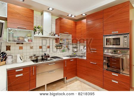 Kitchen Interior With Wooden Furniture And Build In Utensils