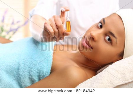 Cosmetic ampoule a woman in the beauty salon vitamin C in cosmetic ampoule.