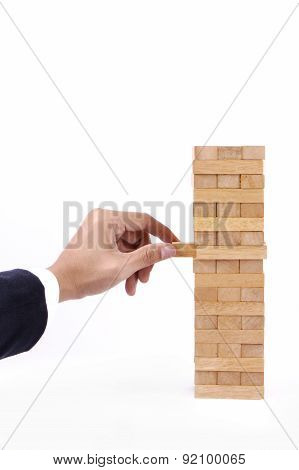 Businessman Hand Playing With The Wood Game (jenga).