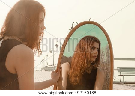Thoughtful Woman Looks At Reflection In Mirror