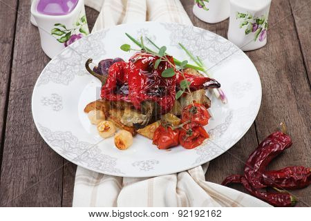 Roasted red peppers with potato and vegetables on white plate