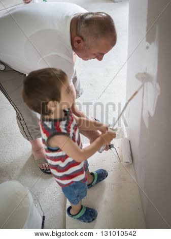Little cute boy painting on a wall