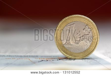 Shot of one euro coin on newspaper chart