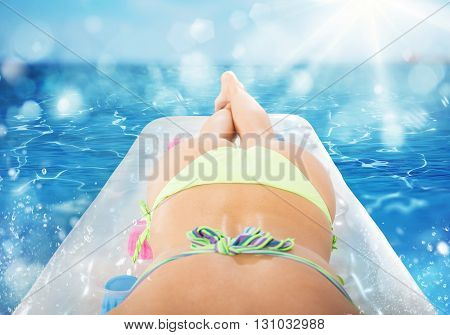 Girl tans on airbed at the sea