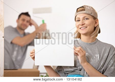 Usmíval se pár obraz nový dům, Žena v zaměření drží prázdné stránky, copyspace.