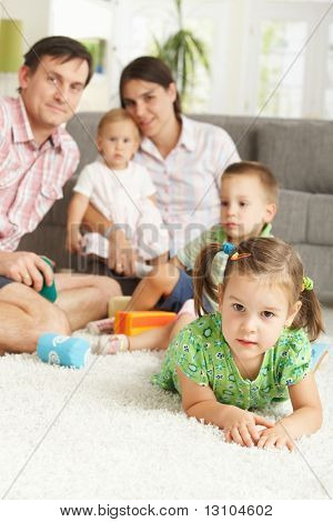 Küçük kız (3-4 yıl) çekirdek aile arka plan ile katta evde yatıyor.