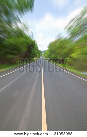 Road in Countryside with zoom blur technique used for high speed motion concept