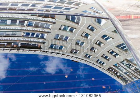Multi-storey contemporary house reflected in the window of the car