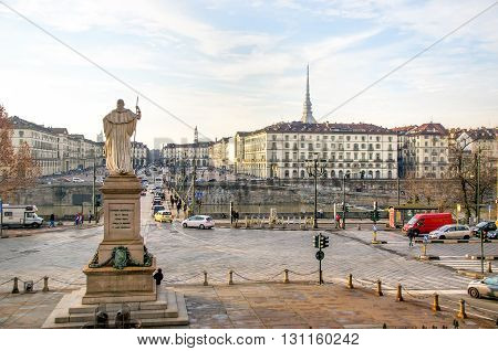 Turin Italy March 9 2013: The king Vittorio Emanuele statue in the Great Mother of God plaza with the Mole Antonelliana landmark building on the background