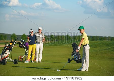Boy golfer with parents plaing golf at sunny day