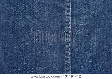 denim or rough cotton fabric or jeans material with the stitched seam for the textile textured background of blue color