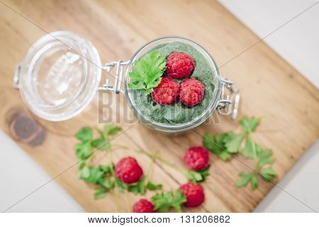 Green Super-useful Mousse With Raspberries. The View From The Top. Glass Jar Mousse On A Board Laid