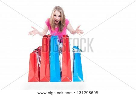 Cheerful shopaholic woman with many present or shopping bags smilling happily with copyspace isolated in white