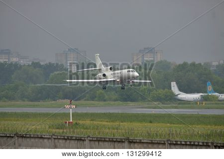 Kiev UKraine - June 5 2012: Dassault Falcon 50EX business jet is landing in bad weather conditions under heavy rain