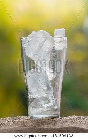ice in the glass on sand ground