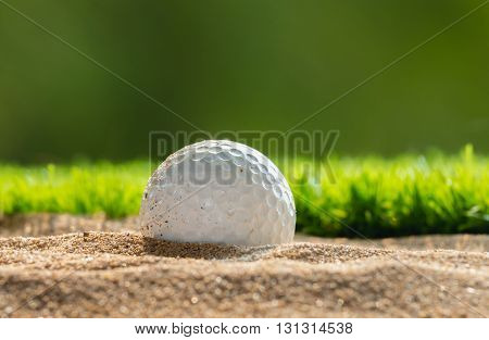 Close up Golf ball in sand bunker