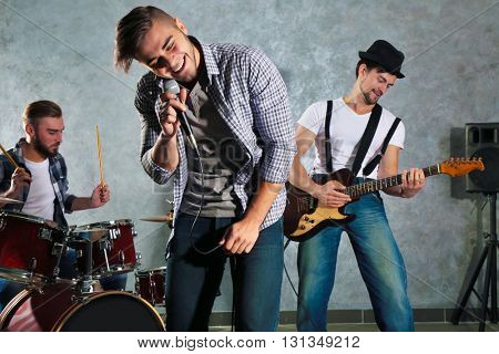 Musicians playing musical instruments and singing songs in a studio