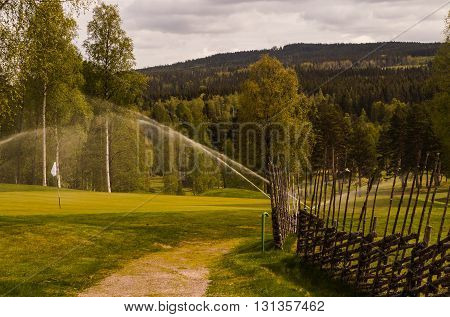 The sprinkler on a wet golf course