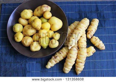 Whole raw yellow oca and olluco in a bowl on a place mat in Peru