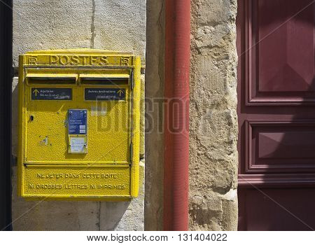 Saint Jean de Luz - Ciboure France - May 21 2016: French yellow metal mailboxes on stone wall in a street of Aquitaine. France.