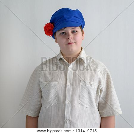 Portrait of a boy teenager in Russian national cap with cloves