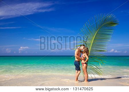 Couple in love with palm leaves on a wild beach. Thailand. Bikini. Lost heaven. Paradise.
