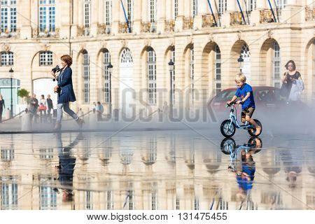 People Having Fun In A Mirror Fountain In Bordeaux, France
