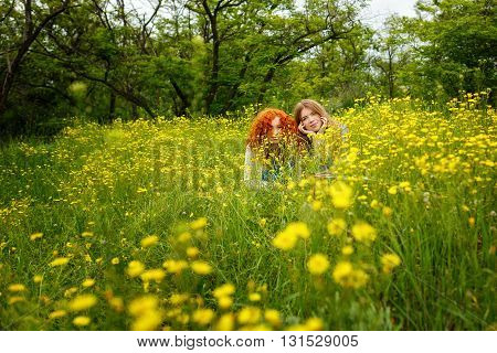 Best friends forever. Girlfriends are hiding in the flowers in the park. BFF. Close friends. Gentle friendship.