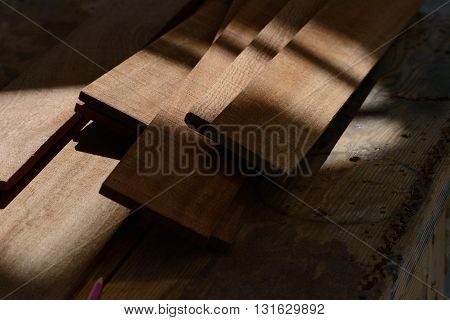 Boat building planks on a workbench in the shade