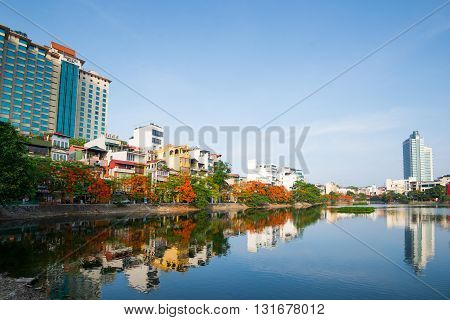 HANOI, VIETNAM, May 21, 2016: Hanoi street in summer with blooming flamboyant flowers near the lake