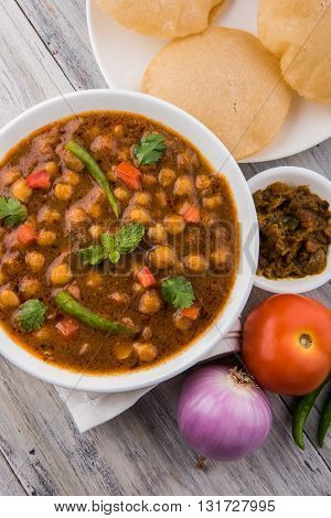 indian dish spicy Chick Peas also known as Chola Masala or Chana Masala or Chole served in a white bowl, isolated