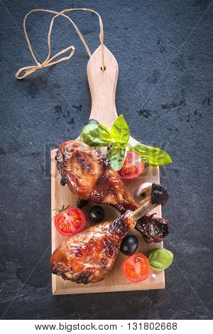 Chicken legs on wooden board on rustic background