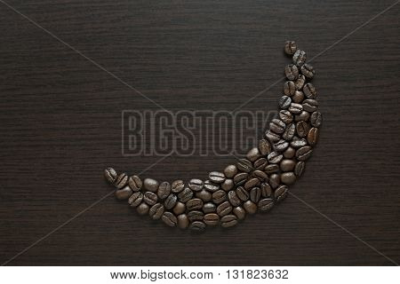 Roasted black coffee beans arranged in a moon shape on dark background. Coffee beans in moon shape - Ramadan food concept.