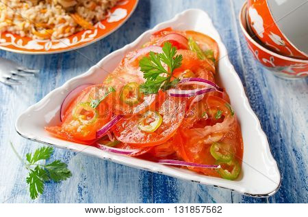 Vegetable salad from tomatoes with onions and hot peppers. Traditional Uzbek salad that is served with pilaf