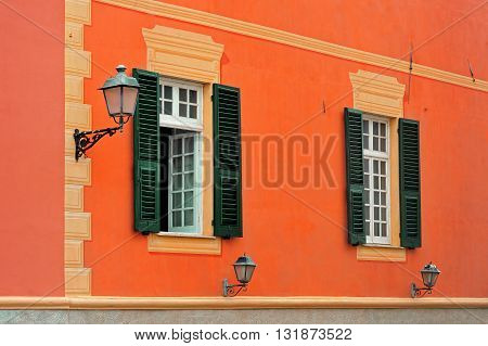 Italian orange facade with shuttered windows and lamp