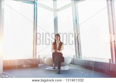 Double exposure with young Japanese woman is chatting on-line via mobile phone while is sitting in luxury loft interior with modern design. Asian female manager using cell phone for checking e-mail