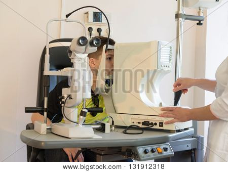 The doctor checks the child's eyes to the device