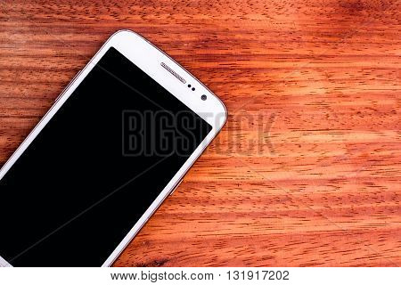 Mobile phone, communication device on a wooden background