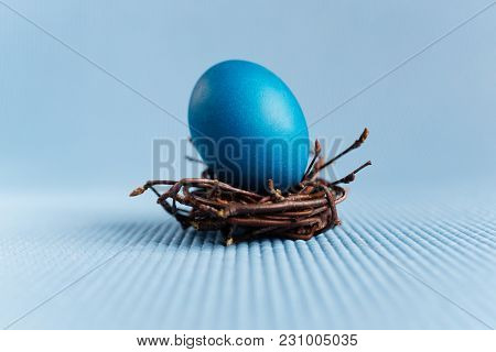 Easter Egg In The Nest On Blue Background