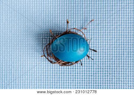 Easter Egg In The Nest On Blue Background
