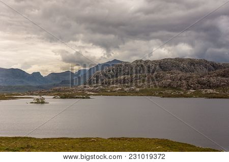 Loch Tollaidh, Scotland - June 9, 2012: Heavy Dark Brown Cloudscape Over Lake Colors Water As Brown.