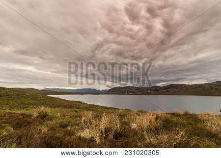 Loch Tollaidh, Scotland - June 9, 2012: Heavy Dark Brown Cloudscape Over Lake Colors Water Dark. Set